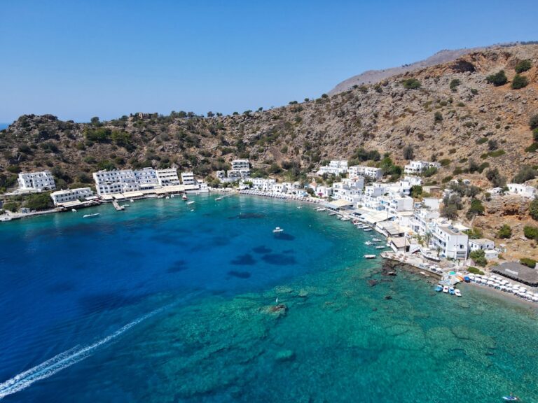 an aerial view of a beach with boats in the water