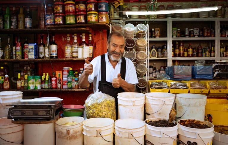 Man behind a market stall with buckets and thumbs up